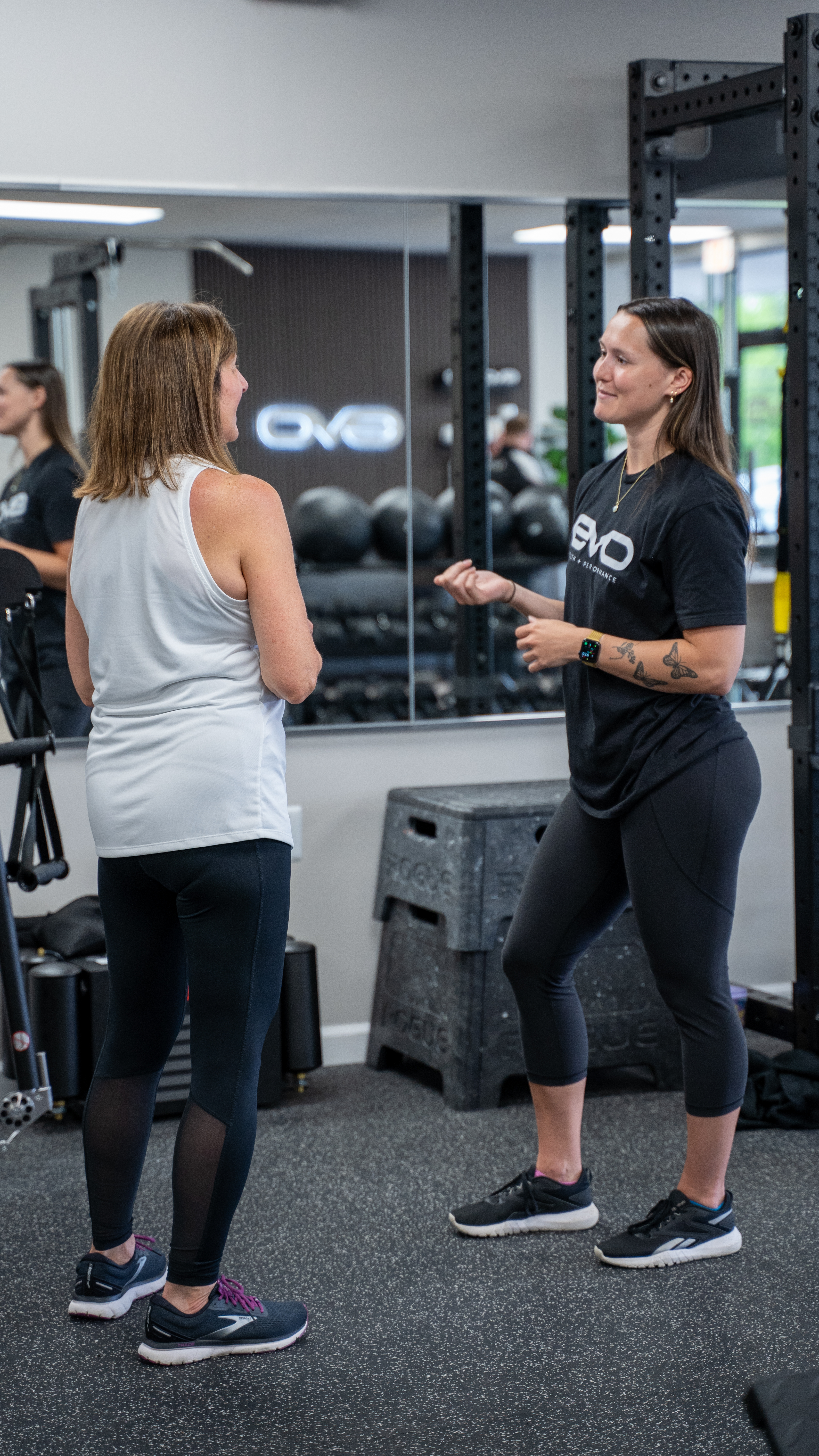 An EVO coach talking with a member in the gym